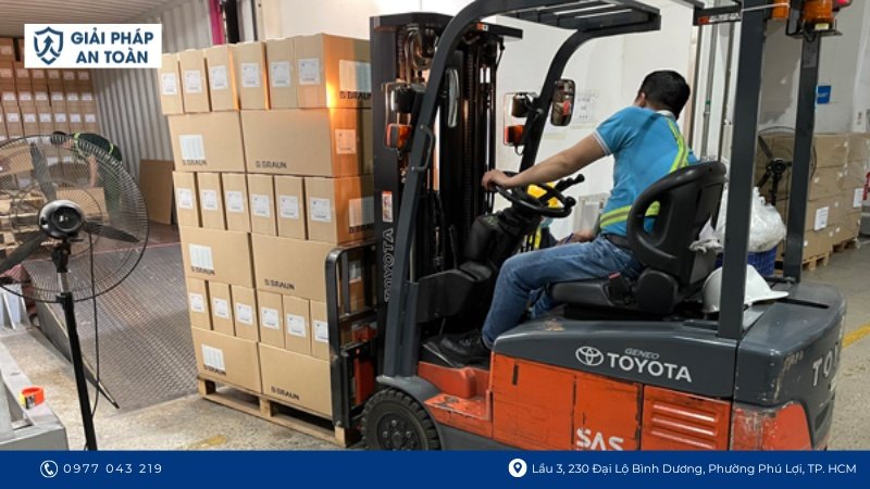 Công nhân đang lái xe nâng hàng thùng cartone